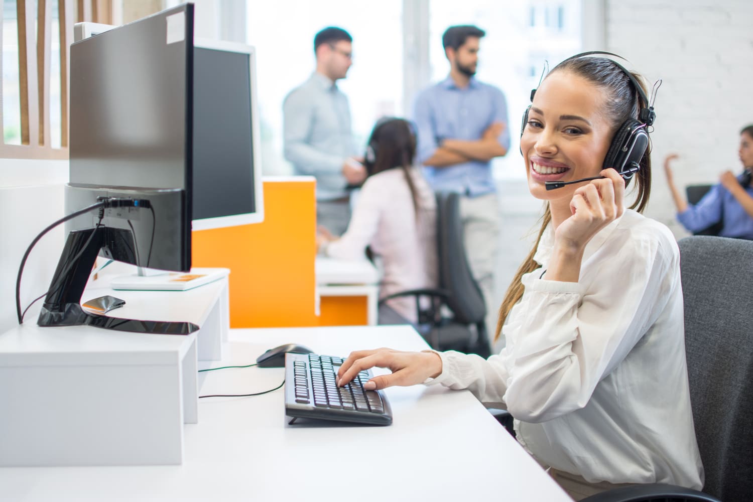 Atendente sorridente no call center da LMB Distribuidora